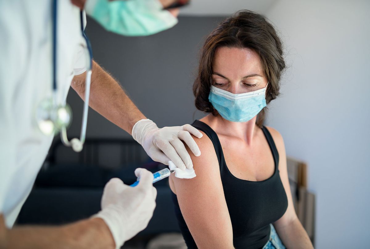 Woman with face mask getting vaccinated (Getty Images)