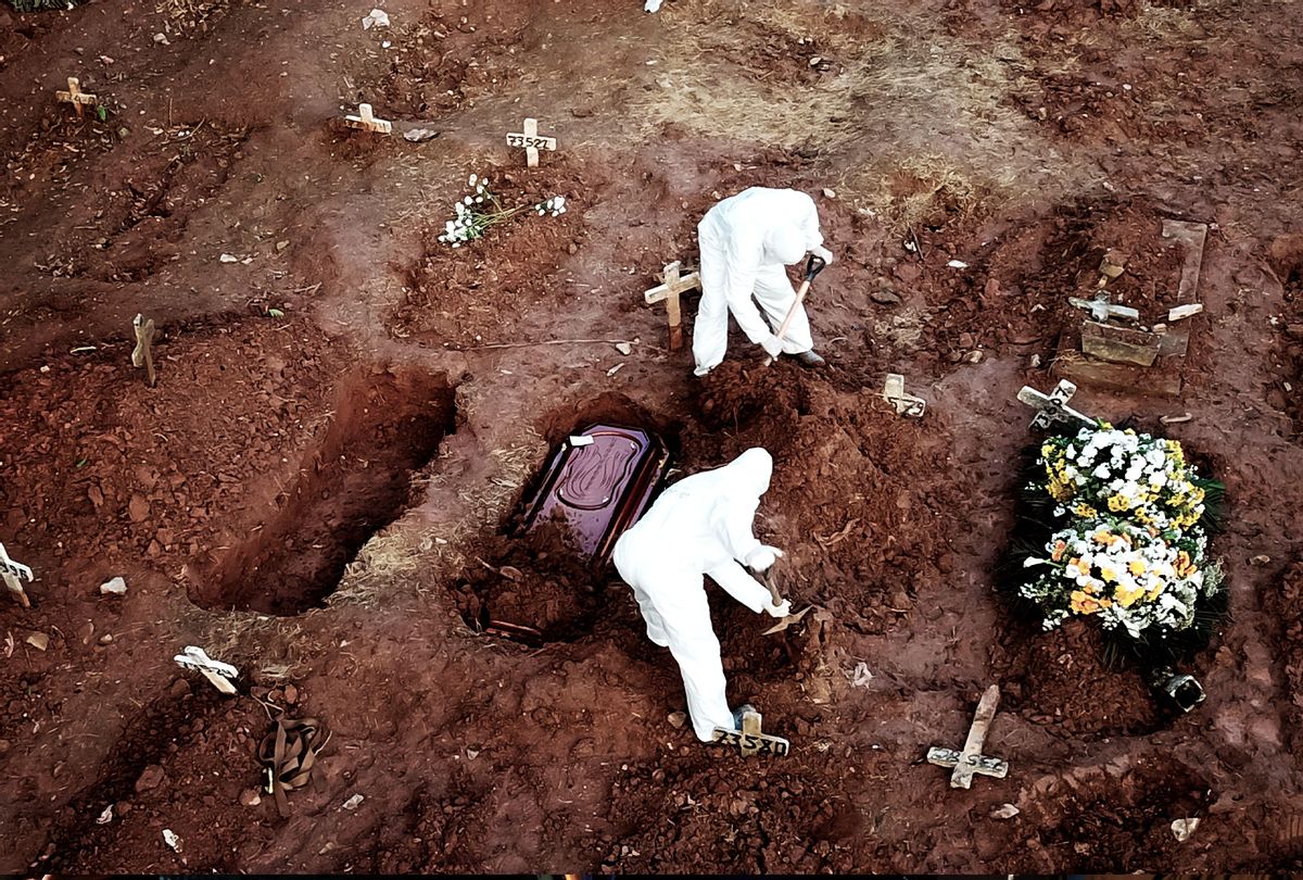 Workers in hazmat suits dig graves for those who dies due to COVID-19 (Buda Mendes/Getty Images)