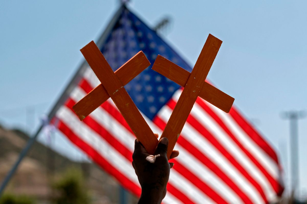 Crosses in front of a US flag. (GUILLERMO ARIAS/AFP via Getty Images)