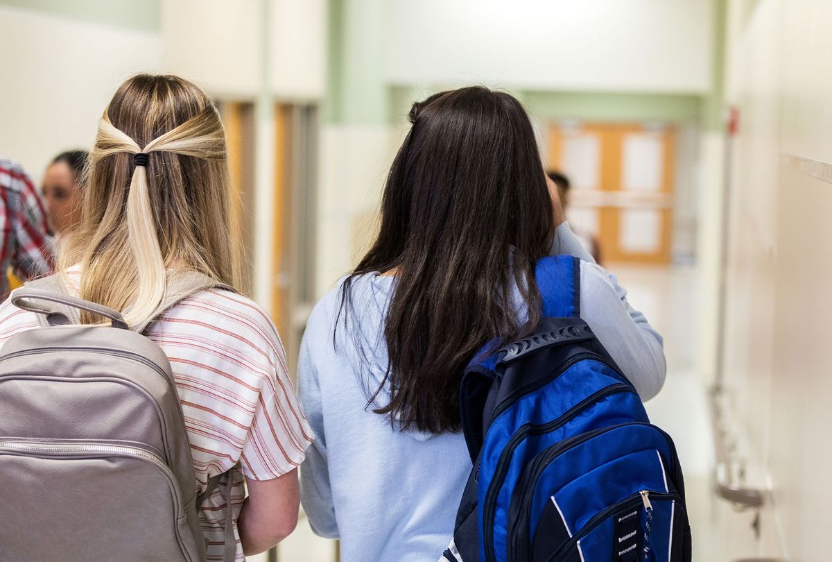 Teen girls with their back packs as they walk down the hallway to class. (Getty Images)