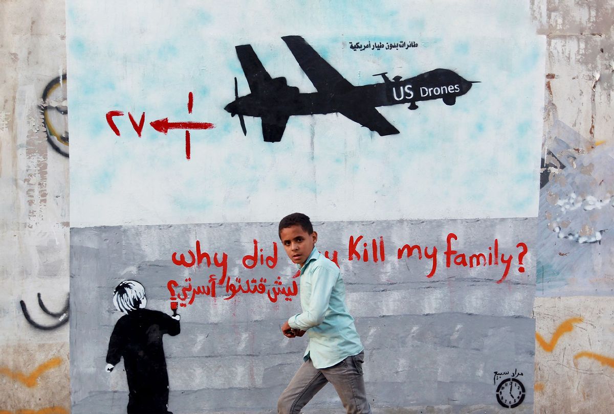 A Yemeni boy walks past a mural depicting a US drone and reading " Why did you kill my family" on December 13, 2013 in the capital Sanaa. (MOHAMMED HUWAIS/AFP via Getty Images)