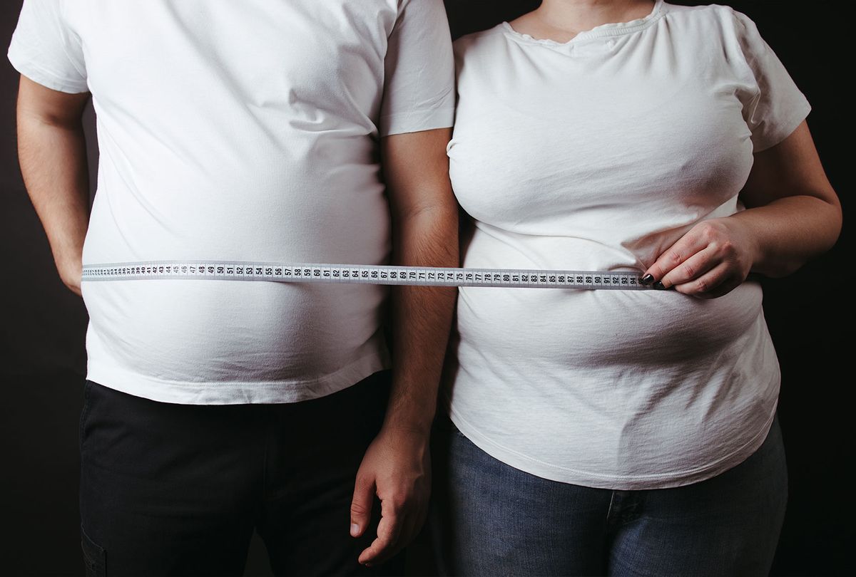 Woman measuring waist with measuring tape,Excess belly fat and overweight  fatty bellys of female Stock Photo