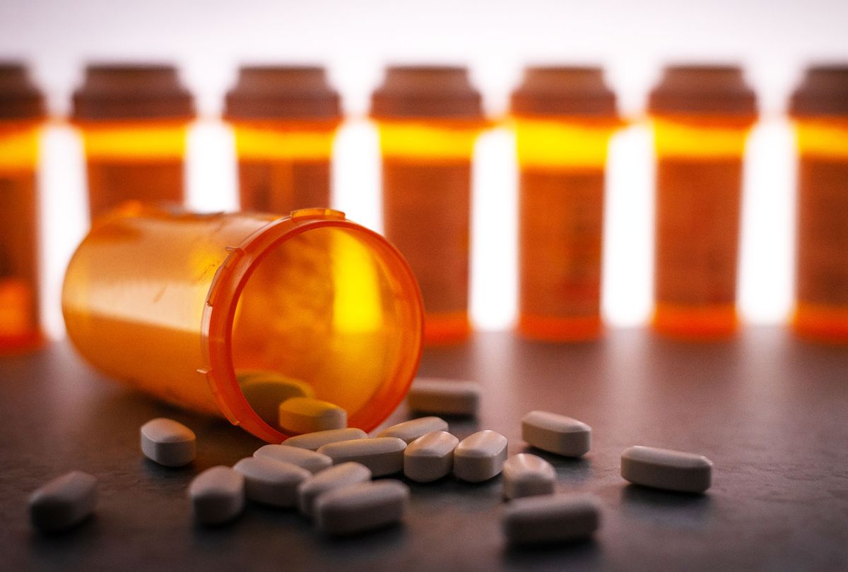 Prescription medication is strewn about, with pill bottles in the deep background. (Getty Images)