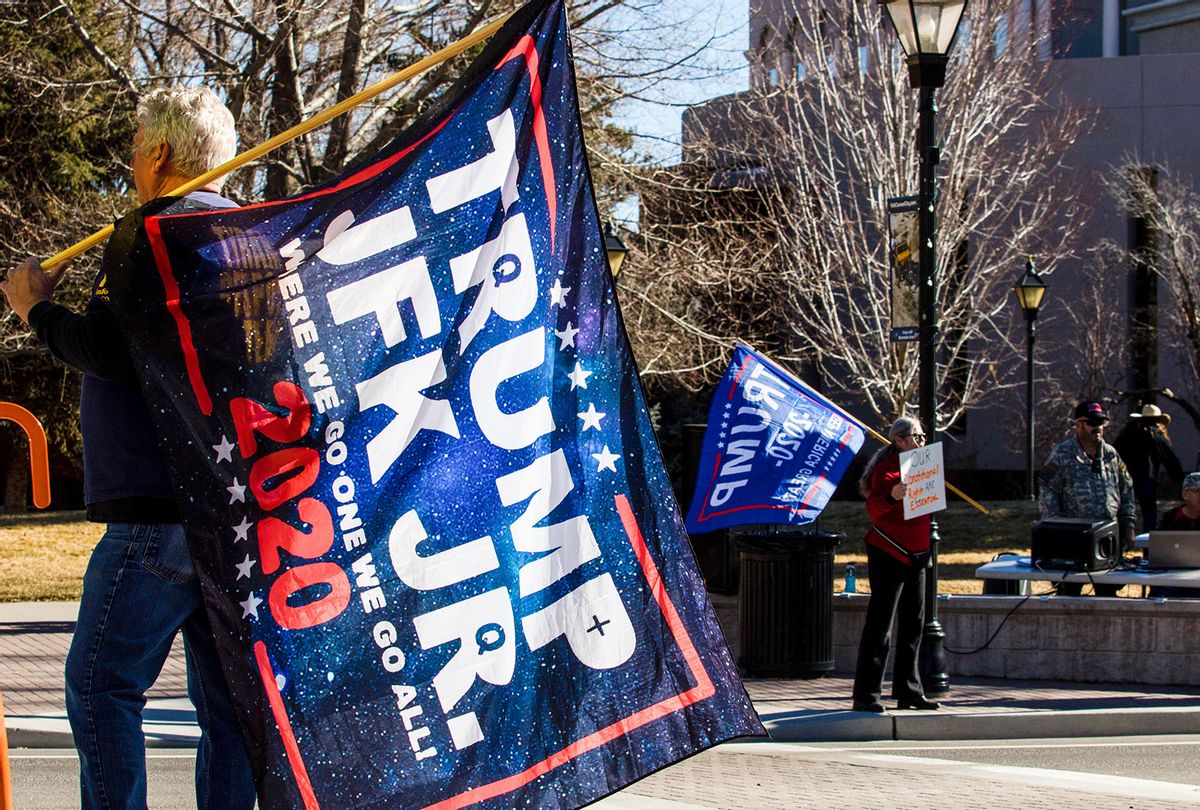 A Qanon believer walks with a "Trump JFK jr." flag. Trump supporters gather at the state capital to protest before Biden's inauguration. (Ty O'Neil/SOPA Images/LightRocket via Getty Images)