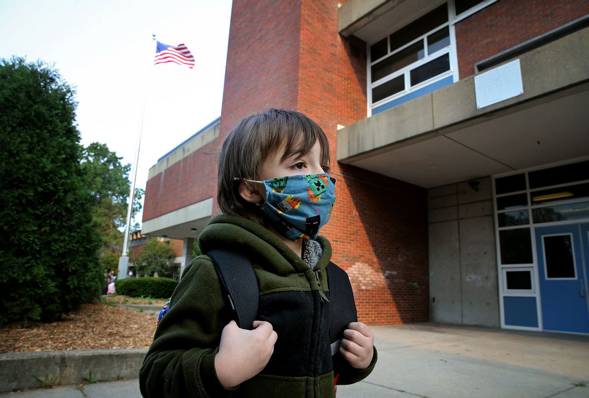 A boy arrives for the first day of school wearing a face mask (Craig F. Walker/The Boston Globe via Getty Images)