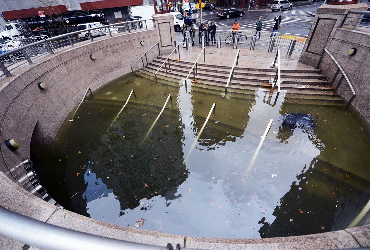 People take photos of water filling the entrance of The Plaza Shops in Battery Park in New York on October 30, 2012 as New Yorkers cope with the aftermath of Hurricane Sandy. The storm left large parts of New York City without power and transportation. (TIMOTHY A. CLARY/AFP via Getty Images)