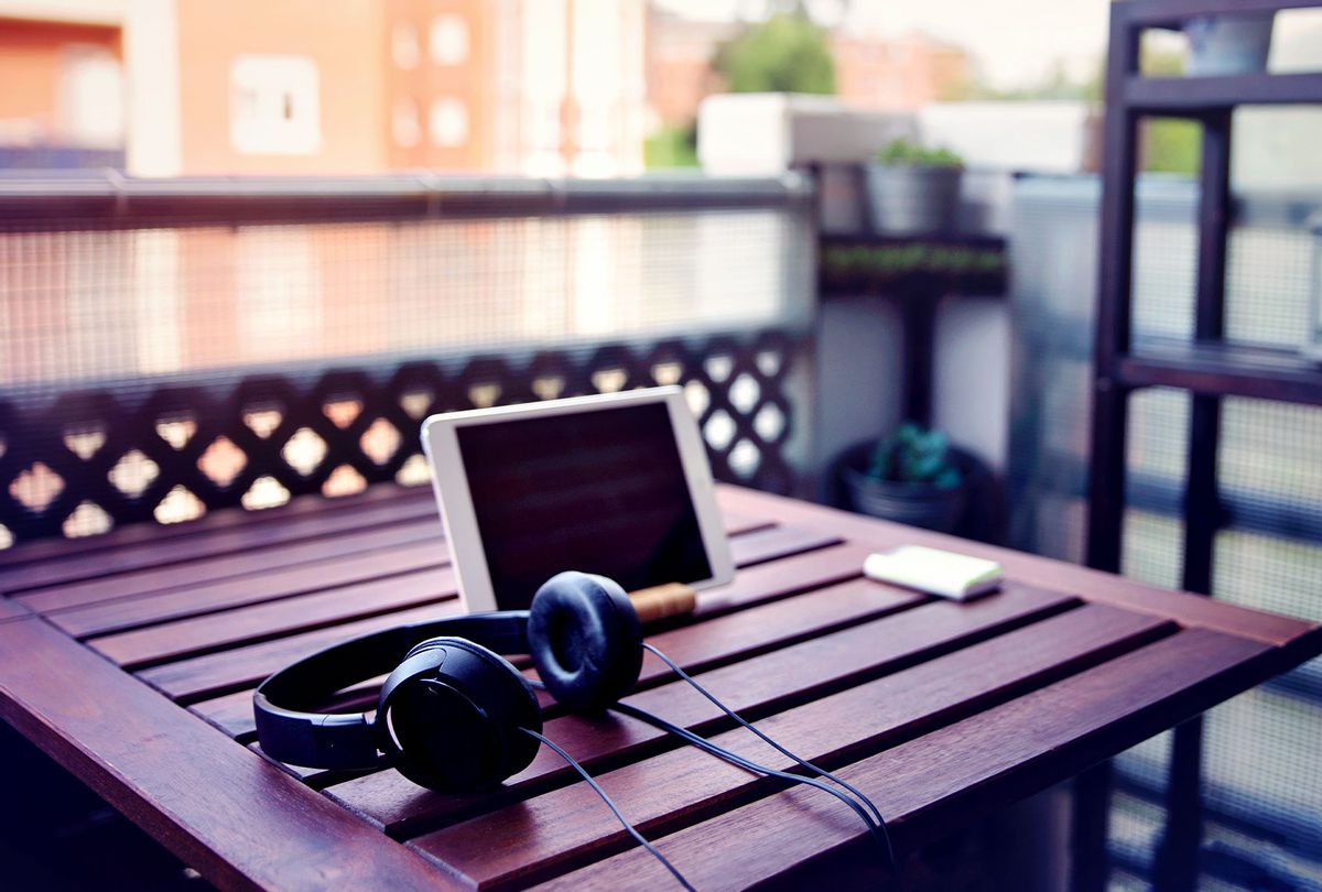Improvised desk on the balcony, with a wooden table, a digital tablet and headphones (Getty Images/Sol de Zuasnabar Brebbia)