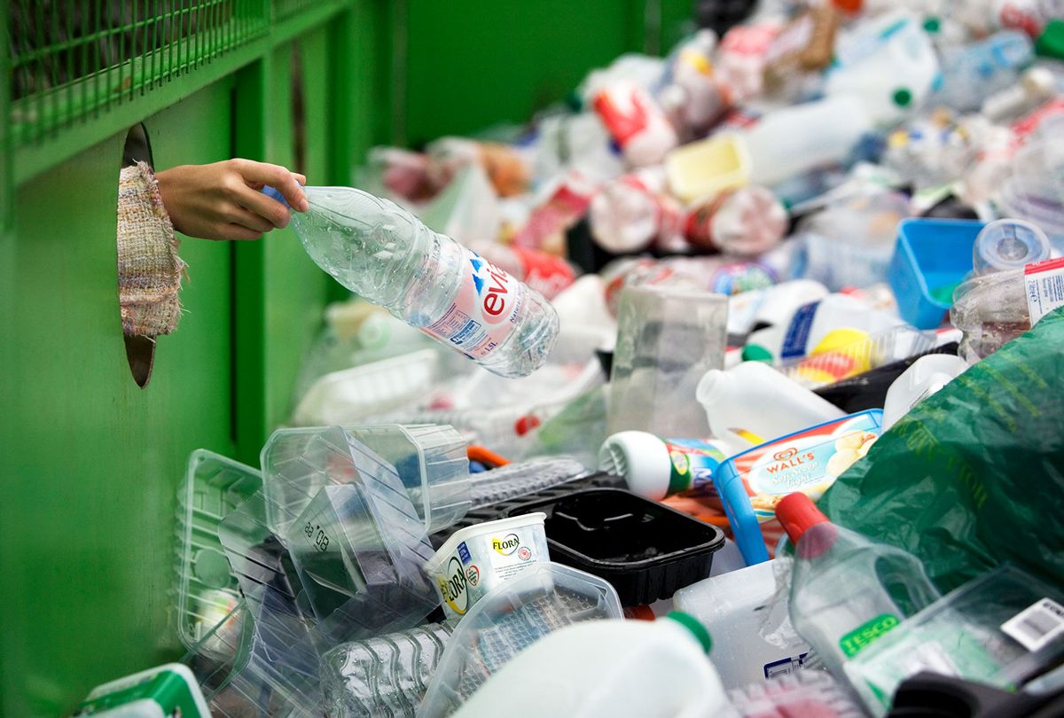 A woman depositing a plastic bottle in a recycling bin (Getty Images/Andrew Fox)