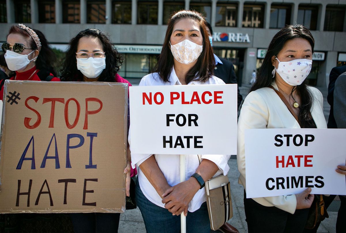 Asian community members hold signs calling for hate to stop at news conference organized to take a unified stand opposing hate crimes against members of the Asian Pacific Islander community on Monday, March 22, 2021 in Los Angeles, CA. (Jason Armond / Los Angeles Times via Getty Images)