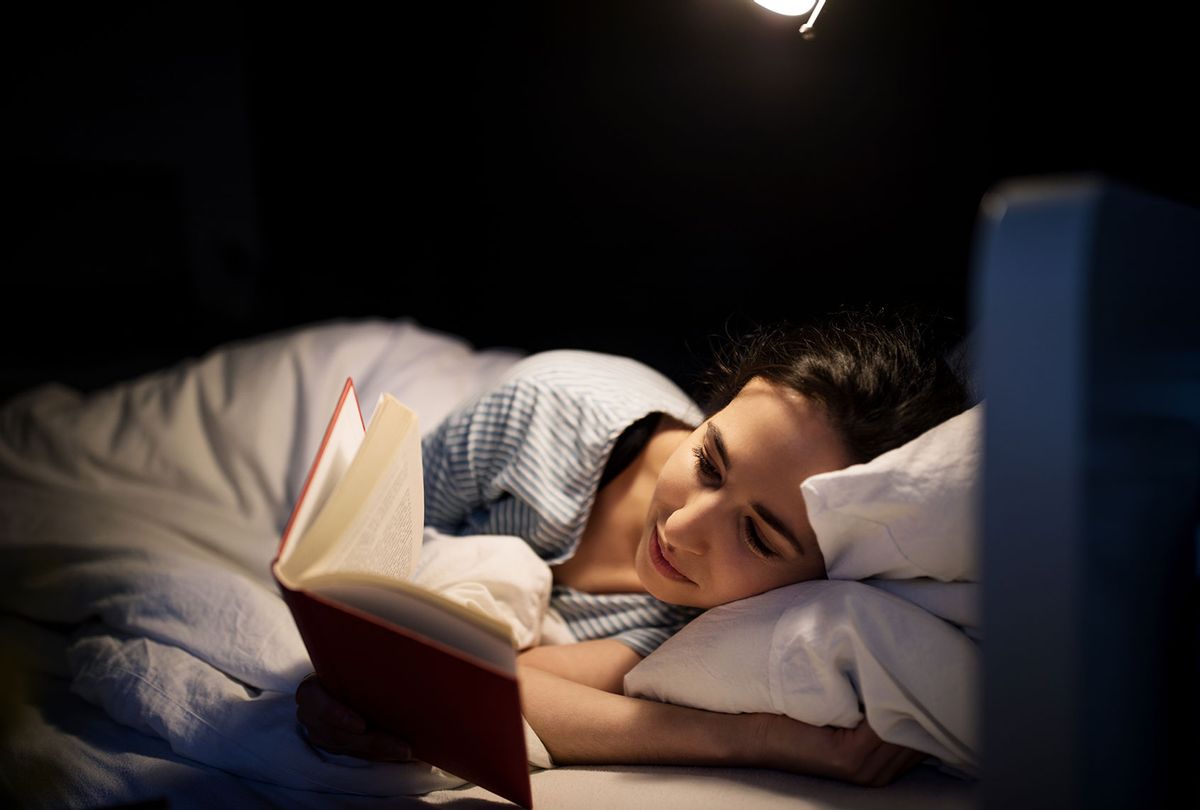 Woman reading in bed (Getty Images/Luis Alvarez)
