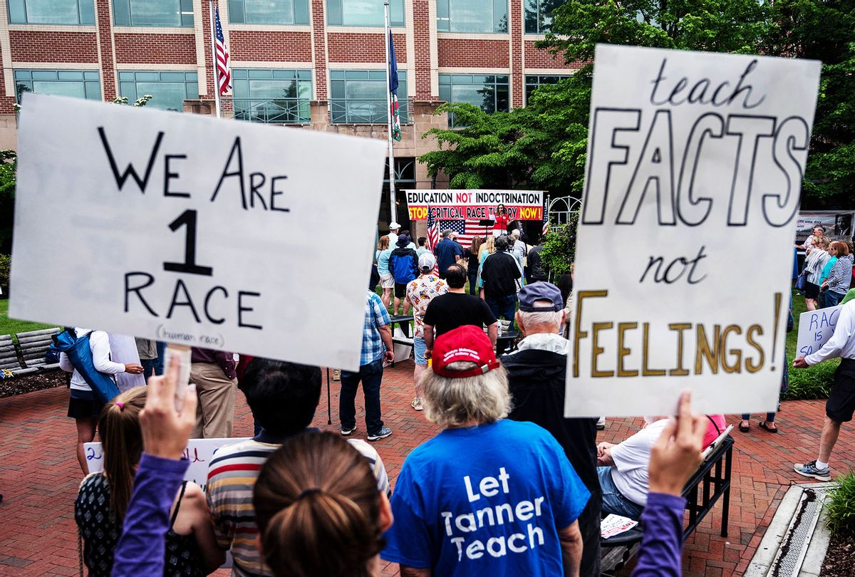 People hold up signs during a rally against "critical race theory" (CRT) being taught in schools at the Loudoun County Government center in Leesburg, Virginia on June 12, 2021. (ANDREW CABALLERO-REYNOLDS/AFP via Getty Images)