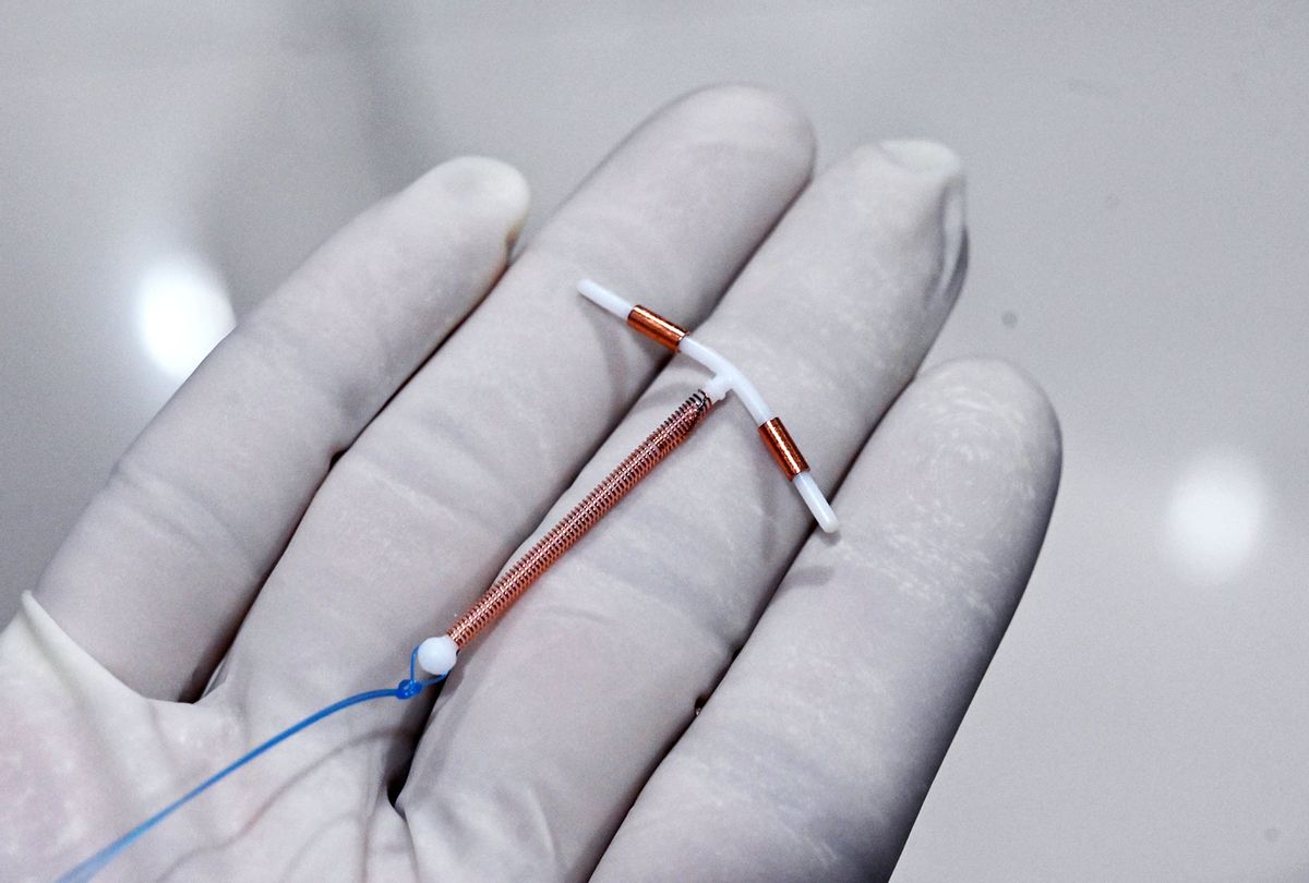 A doctor holding an IUD birth control device  (ADEK BERRY/AFP via Getty Images)