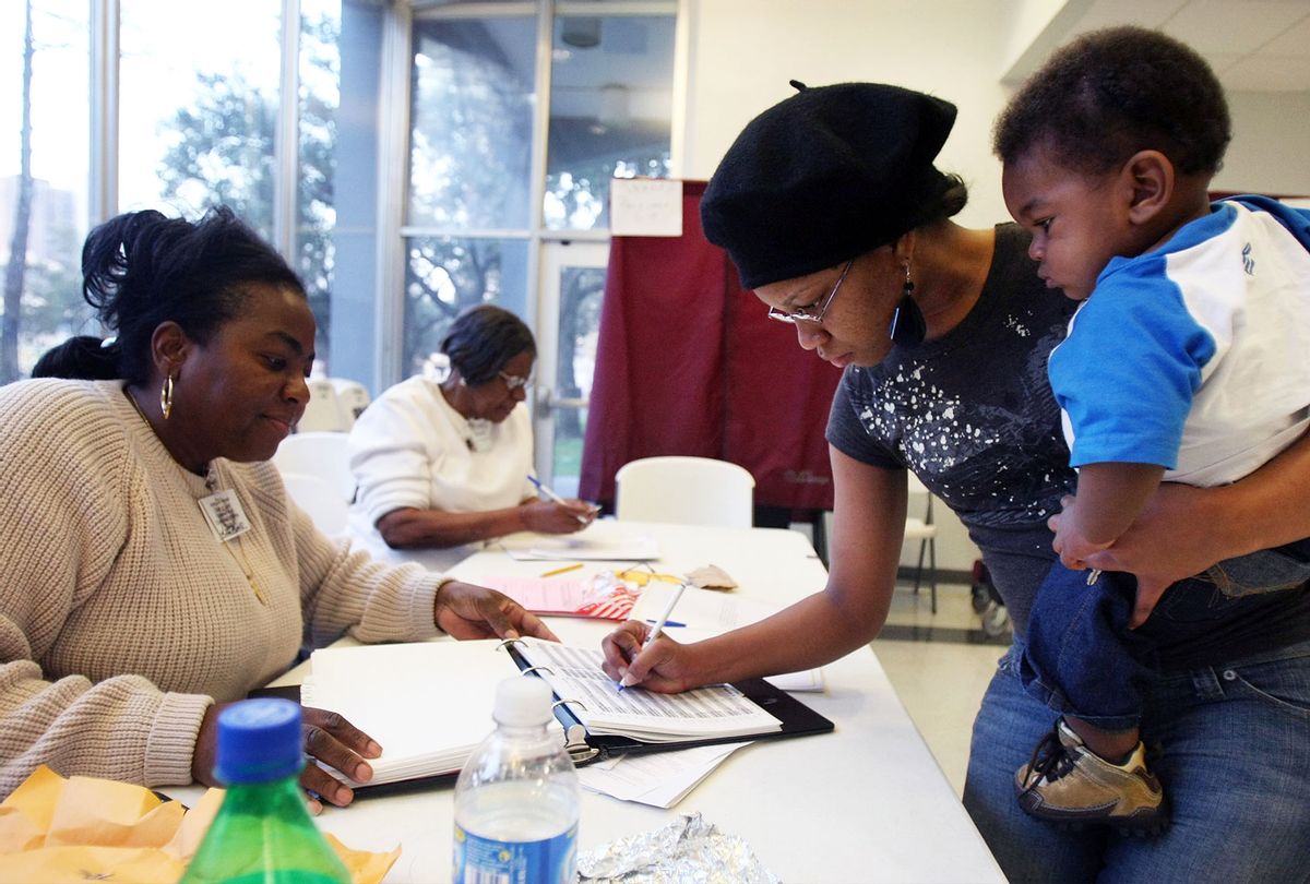 Poll worker looks on as a female voter is signing in during the state's presidential primary in New Orleans, Louisiana.  (Mario Tama/Getty Images)