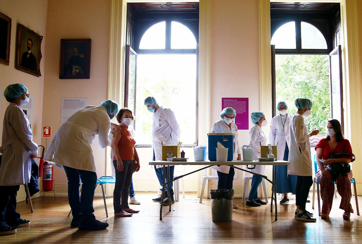 Public health workers vaccinate people at a COVID-19 vaccination clinic at Museu da Republica (Museum of the Republic) on May 24, 2021 in Rio de Janeiro, Brazil. (Mario Tama/Getty Images)
