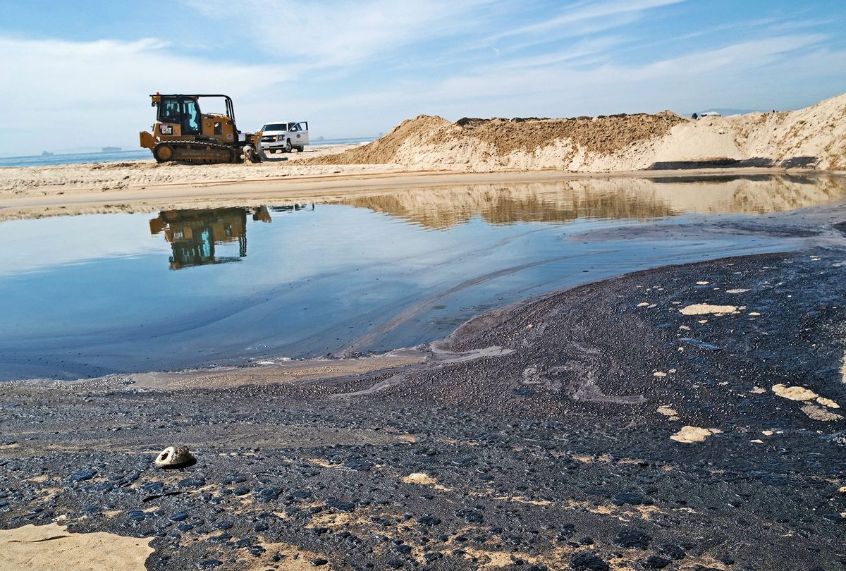 A bulldozer moves sand as oil is washed up on Huntington State Beach after a 126,000-gallon oil spill from an offshore oil platform on October 3, 2021 in Huntington Beach, California. The spill forced the closure of the popular Great Pacific Airshow with authorities urging people to avoid beaches in the vicinity. (Nick Ut/Getty Images)