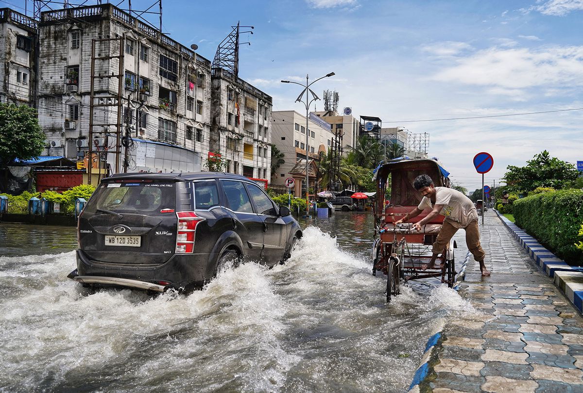 A vehicle passes through a flooded street. All the major roads are flooded after the heavy rain during monsoon at Kolkata, West Bengal, India (Dibakar Roy/Pacific Press/LightRocket via Getty Images)