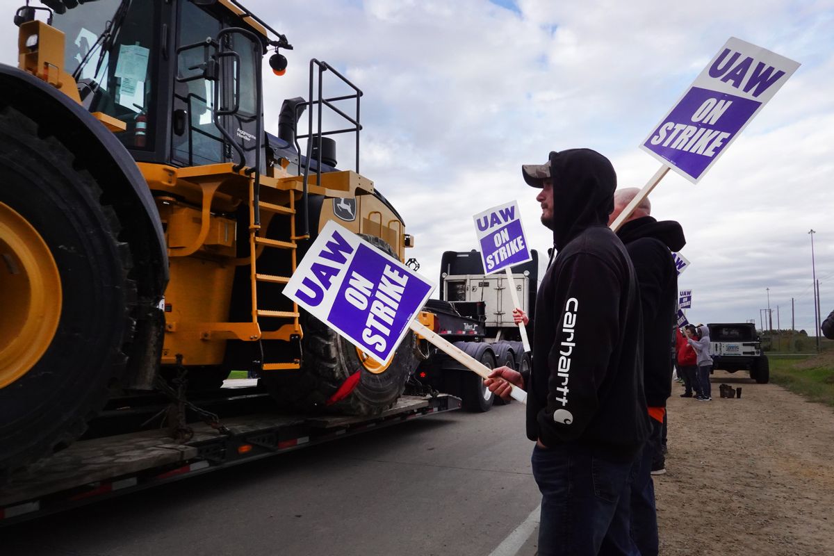 A truck hauls a piece of Deere equipment from the factory past workers picketing outside of the John Deere Davenport Works facility on October 15, 2021 in Davenport, Iowa. (Getty Images)