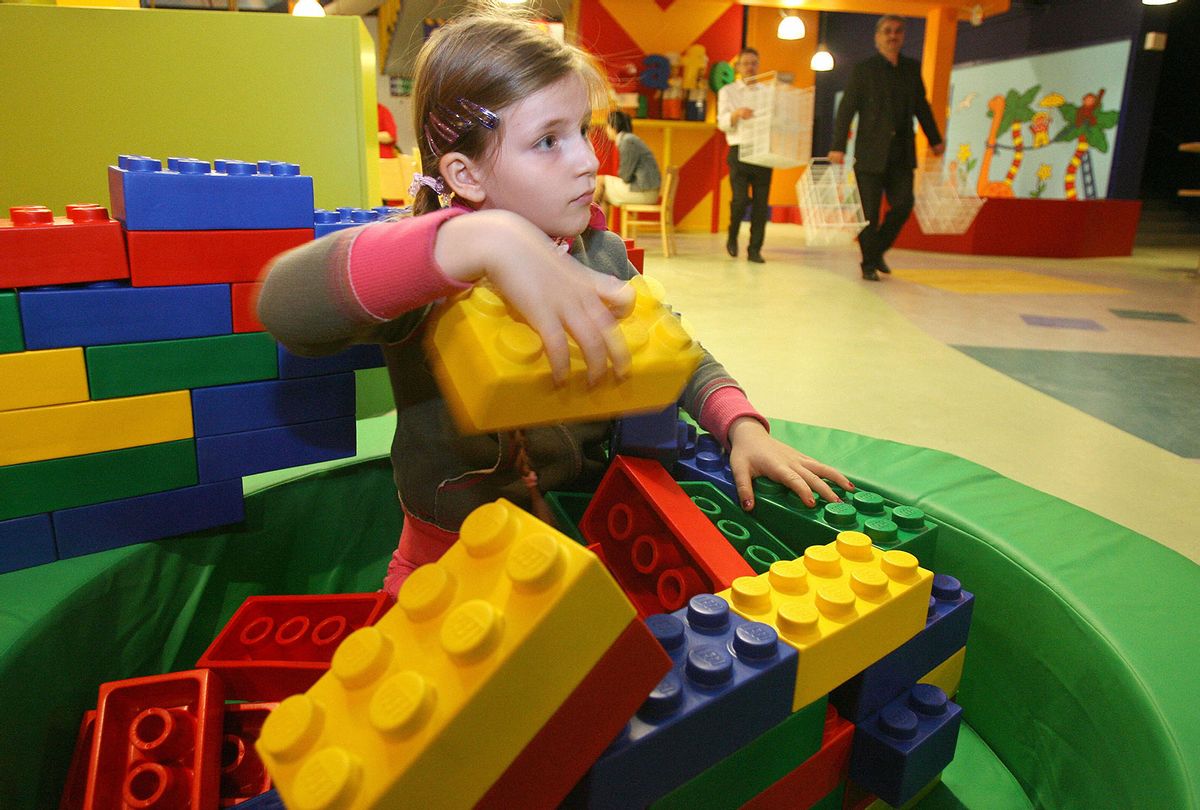 A young girl builds a structure with giant rubber Lego bricks at Berlin's Legoland Discovery Centre in 2007 (JOHN MACDOUGALL/AFP via Getty Images)