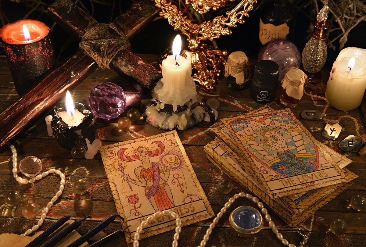 Mystic ritual with tarot cards, vintage objects, cross and candles. (Getty Images/Vera Petruk)