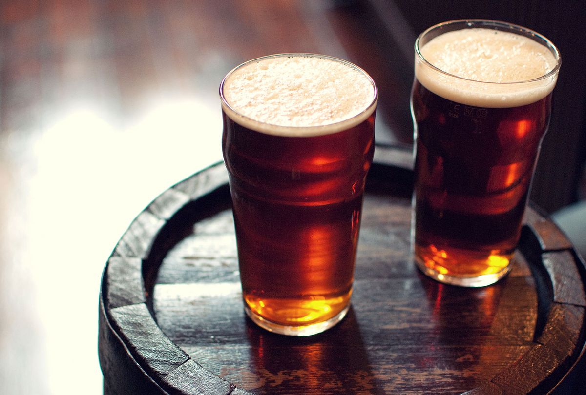 Two pints of beer bitter on wooden barrel in pub. (Getty Images/Adermark Media)