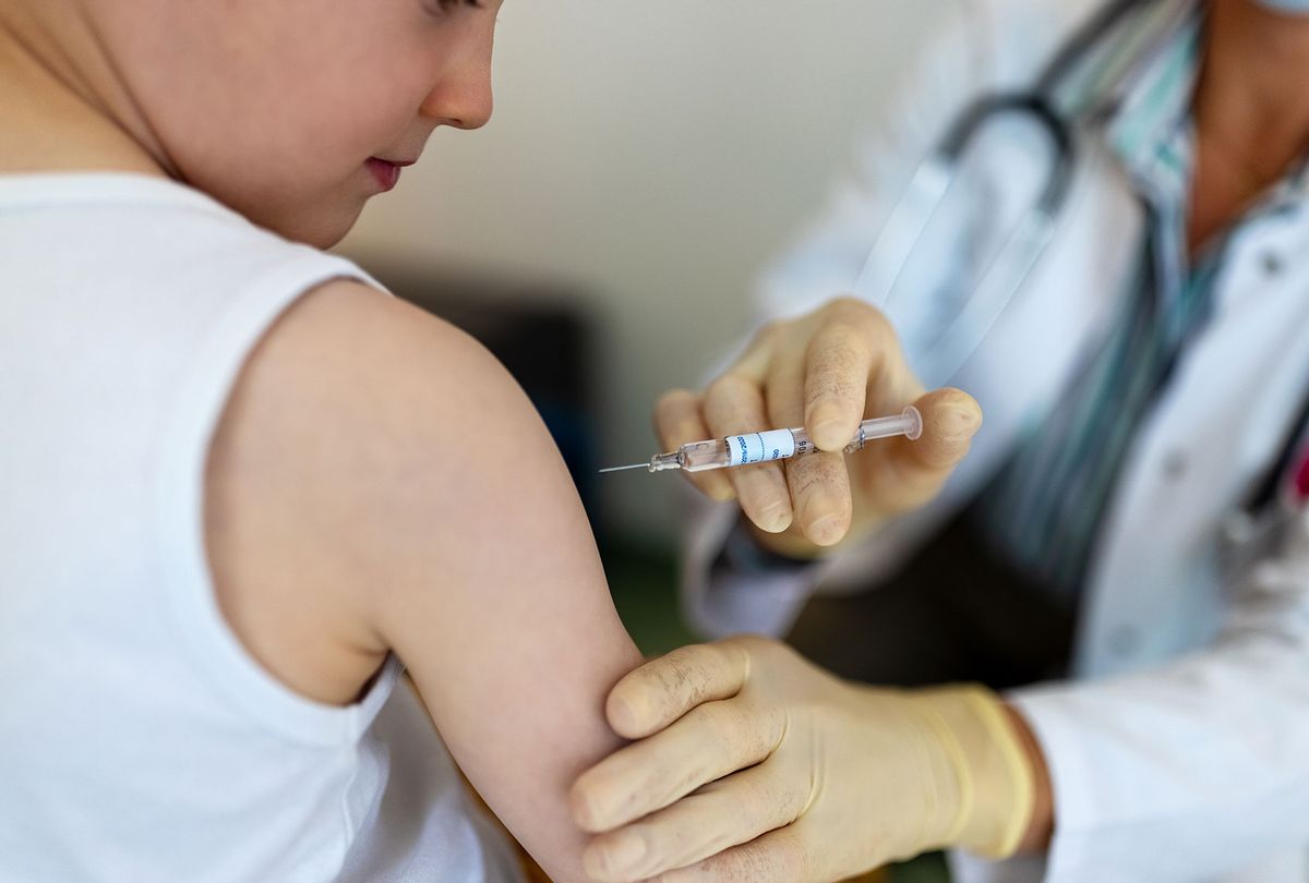 Small boy getting a vaccine on his arm by a pediatrician wearing gloves. (Getty Images/Luis Alvarez)