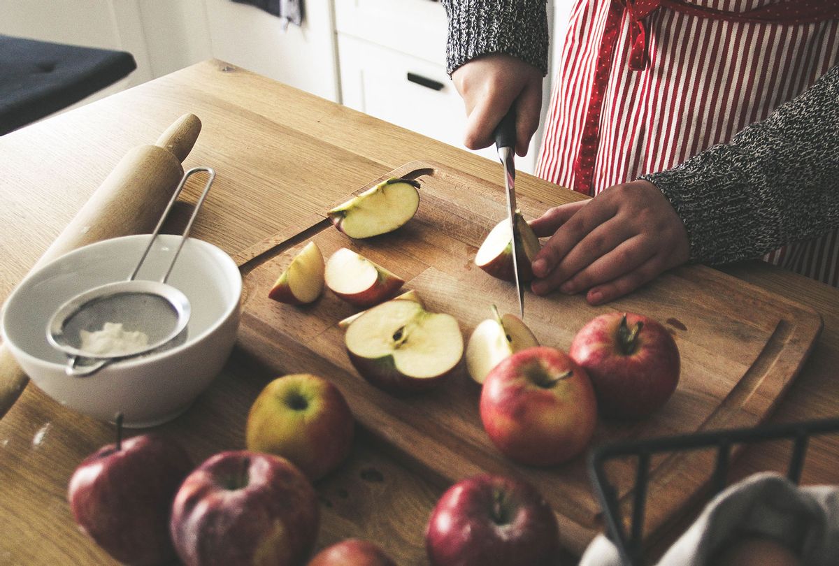 Boy cutting apples for apple pie (Getty Images/Kinga Krzeminska)