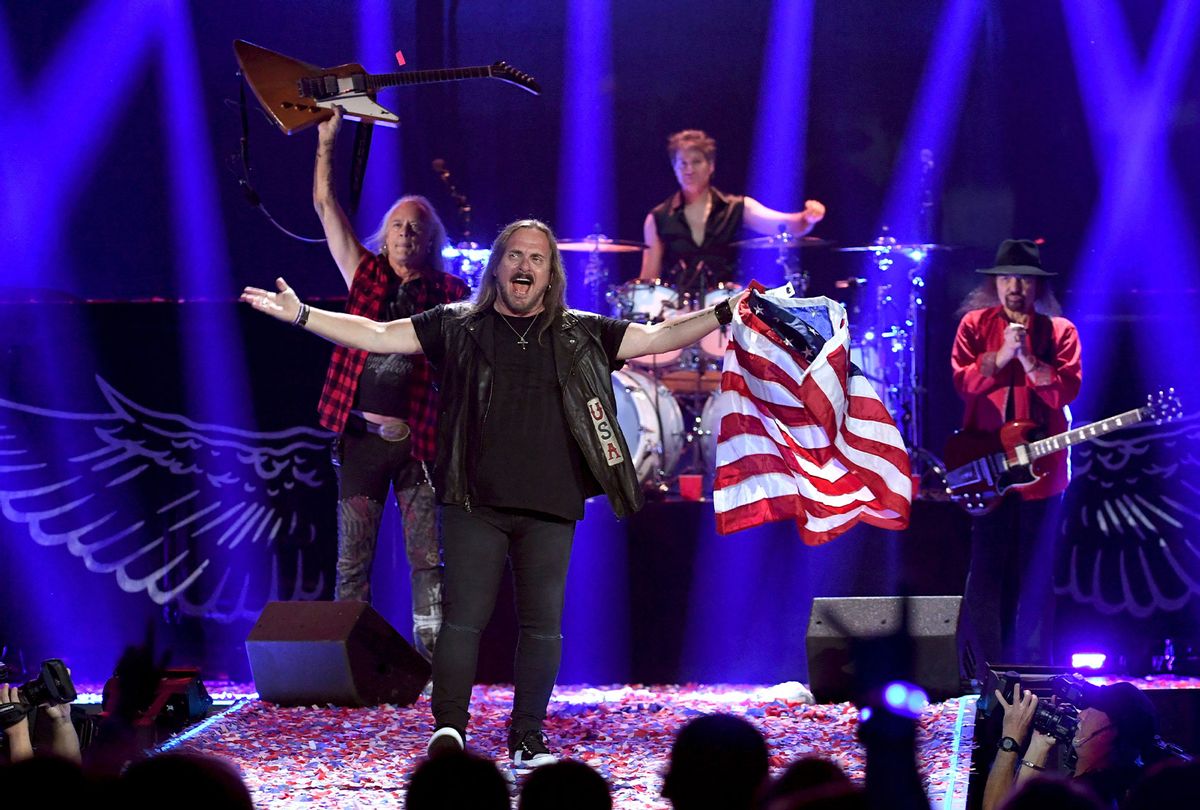 Johnny Van Zant of Lynyrd Skynyrd waves an American flag while the band performs onstage (Kevin Winter/Getty Images for iHeartMedia)