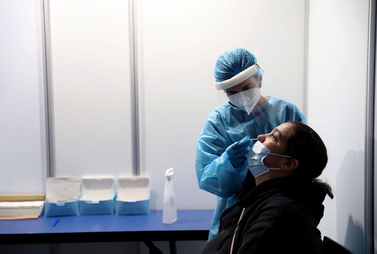 A health worker takes a swab sample from a woman at a COVID-19 testing center (Pedro Fiuza/Xinhua via Getty Images)