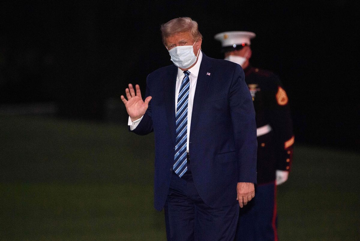 Then-President Donald Trump waves as he arrives at the White House wearing a facemask upon his return from Walter Reed Medical Center, where he underwent treatment for Covid-19. (NICHOLAS KAMM/AFP via Getty Images)