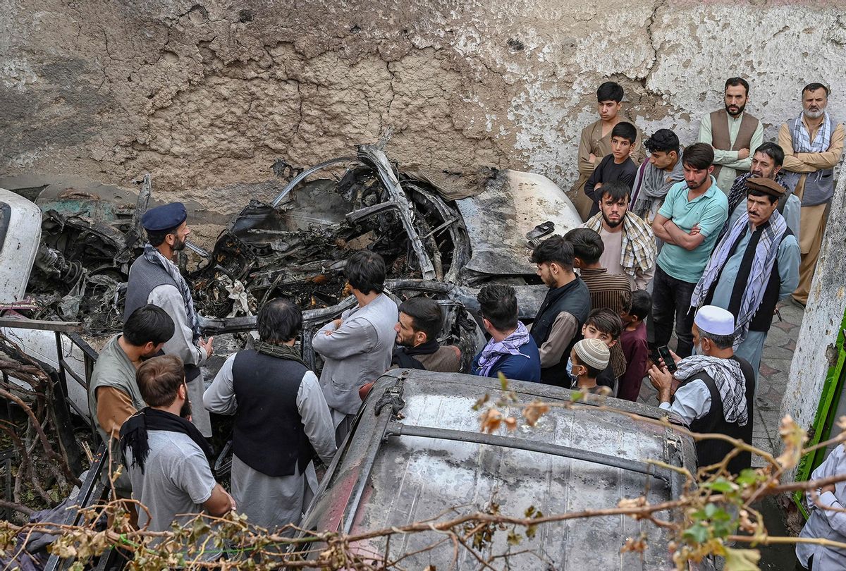 Afghan residents and family members of the victims gather next to a damaged vehicle inside a house, day after a US drone airstrike in Kabul on August 30, 2021. (WAKIL KOHSAR/AFP via Getty Images)