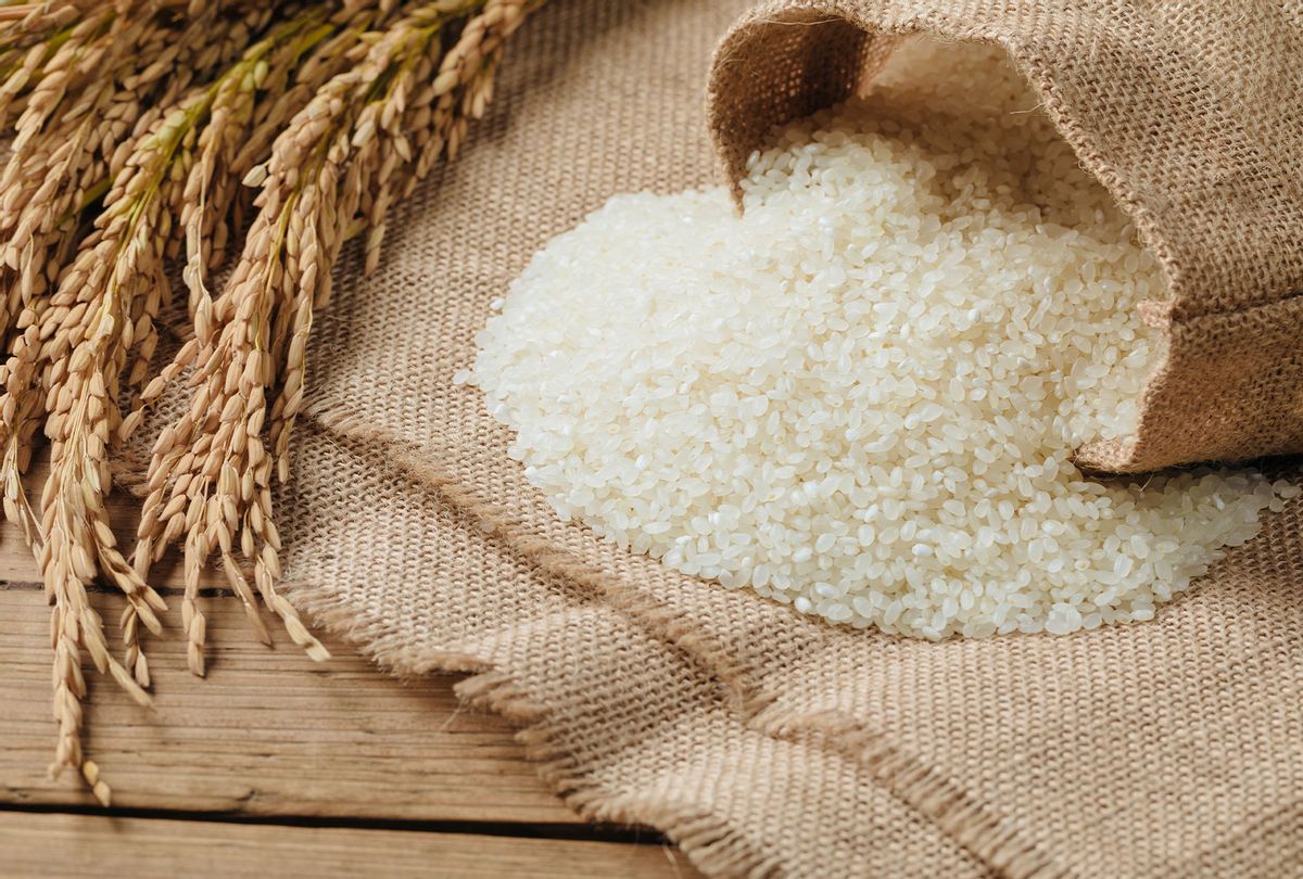 Raw rice grain and dry rice plant on wooden table (Getty Images/ASKA)