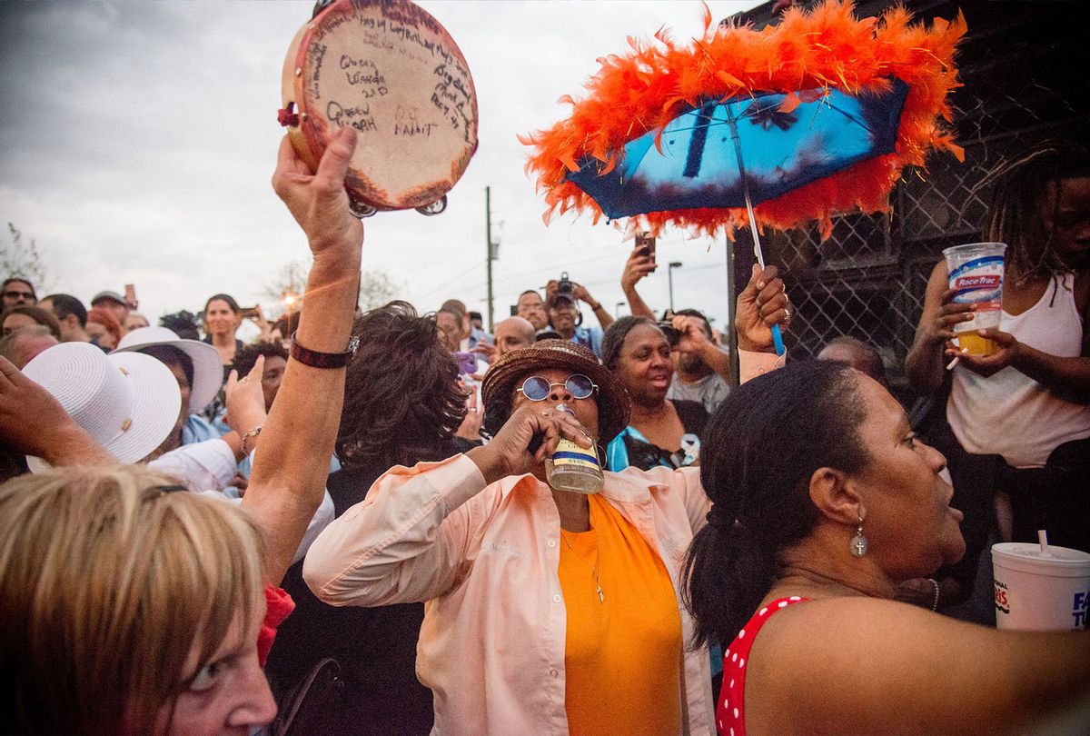 Mary Kay Stevenson enjoys a bottle of liquor and dancing to jazz music during the Second Line for the late Fats Domino in the 9th Ward of New Orleans, Louisiana, November 1, 2017. A traditional parade known as a "second line" was held in New Orleans November 1, 2017 in memory of the American entertainer Fats Domino, who died last week at the age of 89. Domino's death marked the passing of an era in the city, whose uniquely boisterous cultural brew created the musician's sound -- and, with it, rock 'n' roll. (EMILY KASK/AFP via Getty Images)