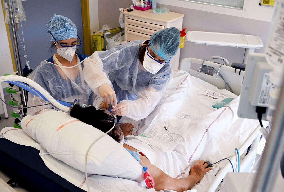 Nurses take care of a patient infected with the Covid-19 at the intensive care unit of the Timone hospital, in Marseille, southern France on January 5, 2022. - France set a record for new Covid cases over a 24-hour period on January 5, 2022 with 335,000 additional infections recorded, Health Minister Olivier Veran told parliament. (NICOLAS TUCAT/AFP via Getty Images)