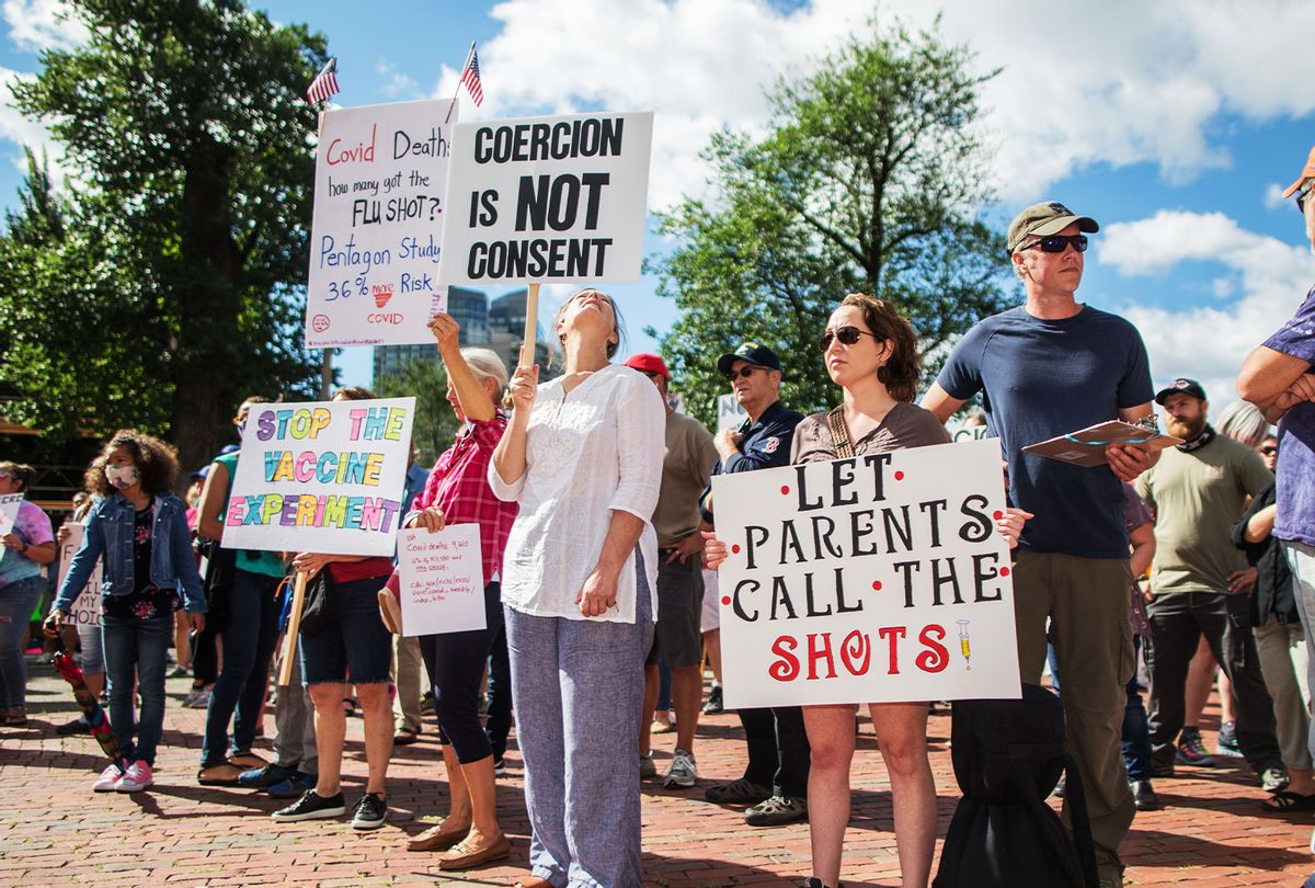 Anti-vaccine activists protest and hold signs in front of the Massachusetts State House against Governor Charlie Baker's mandate that all Massachusetts school students enrolled in child care, pre-school, K-12, and post-secondary institutions must receive the flu vaccine this year on August 30, 2020 in Boston, Massachusetts. (Scott Eisen/Getty Images)