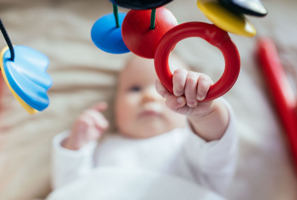 Baby playing with hanging mobile (Getty Images/Guido Mieth)