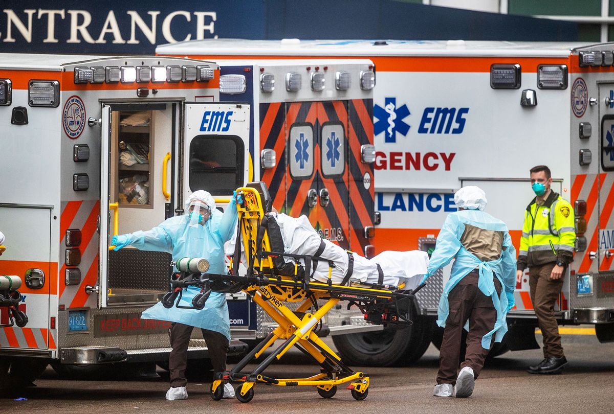 EMTs rush a patient to the emergency room at Massachusetts General Hospital in Boston on March 24, 2020, as the number of confirmed Massachusetts cases of coronavirus soars to near 5,000. (Stan Grossfeld/The Boston Globe via Getty Images)