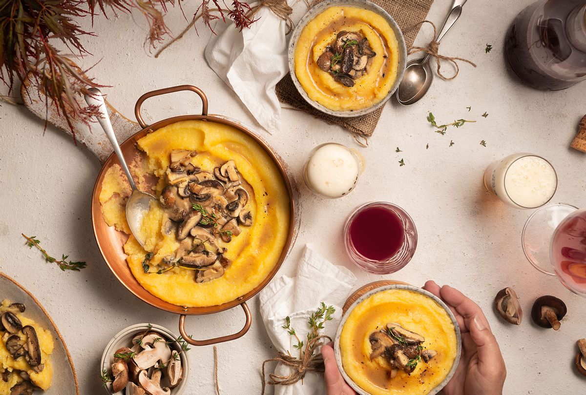 Polenta and shiitake mushroom sauce, both in copper pan and bowls, with red wine and beer glasses (Getty Images/Monica Bertolazzi)