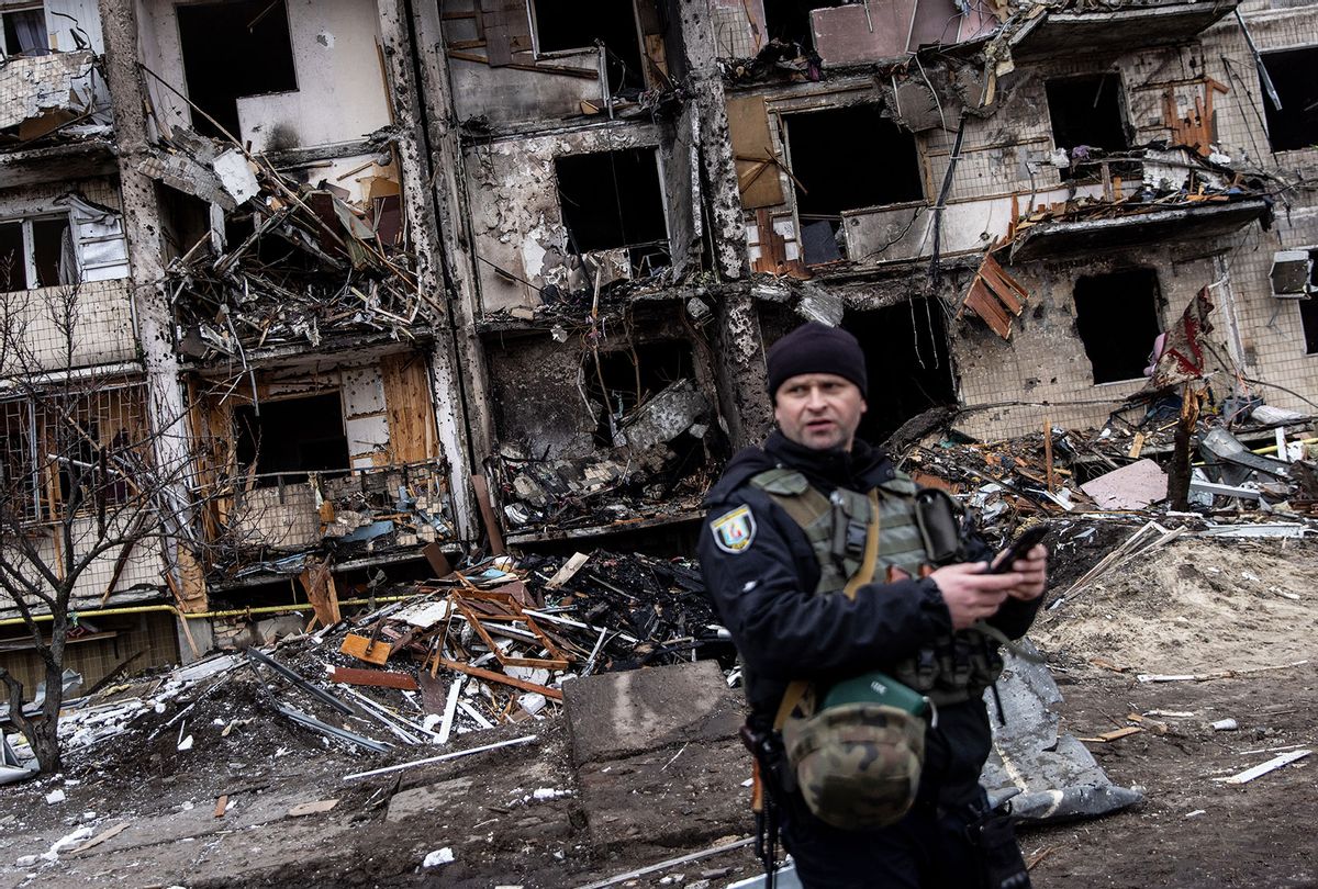 A Ukrainian police officer stands in front of a damaged residential block hit by an early morning missile strike on February 25, 2022 in Kyiv, Ukraine. Yesterday, Russia began a large-scale attack on Ukraine, with Russian troops invading the country from the north, east and south, accompanied by air strikes and shelling. The Ukrainian president said that at least 137 Ukrainian soldiers were killed by the end of the first day. (Chris McGrath/Getty Images)