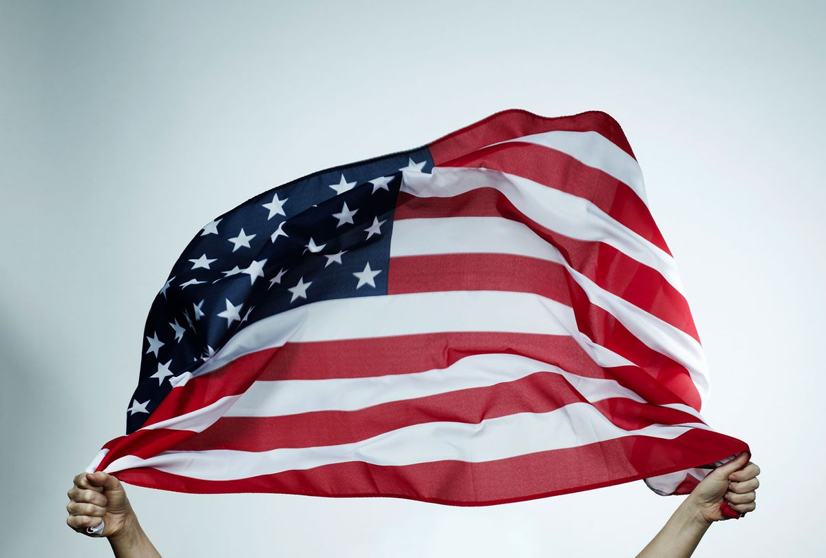 Hands holding American flag (Getty Images/Flashpop)