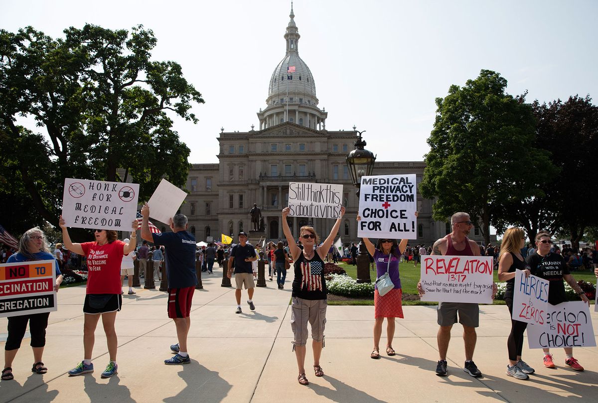 A group demonstrators hold signs as they protest against mandated vaccines outside of the Michigan State Capitol on August 6, 2021 in Lansing, Michigan. There were 44 counties in Michigan at high or substantial levels of community coronavirus transmission, according to the U.S. Centers for Disease Control and Preventions case and test positivity criteria as of August 5, 2021. (Emily Elconin/Getty Images)