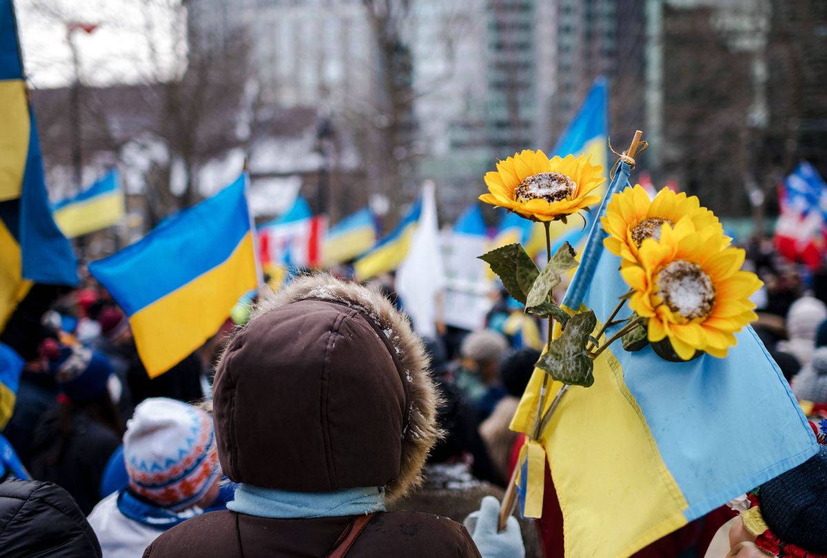 A person holds sunflowers and a Ukrainian flag as members of the Ukrainian community protest at Place du Canada in Montreal, Quebec, on February 27, 2022. - Tens of thousands of Ukrainians have fled their country since Russian President Vladimir Putin unleashed a full-scale invasion on Thursday. (ANDREJ IVANOV/AFP via Getty Images)