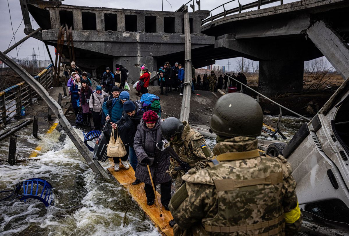 Evacuees cross a destroyed bridge as they flee the city of Irpin, northwest of Kyiv, on March 7, 2022. - Ukraine dismissed Moscow's offer to set up humanitarian corridors from several bombarded cities on Monday after it emerged some routes would lead refugees into Russia or Belarus. The Russian proposal of safe passage from Kharkiv, Kyiv, Mariupol and Sumy had come after terrified Ukrainian civilians came under fire in previous ceasefire attempts. (DIMITAR DILKOFF/AFP via Getty Images)