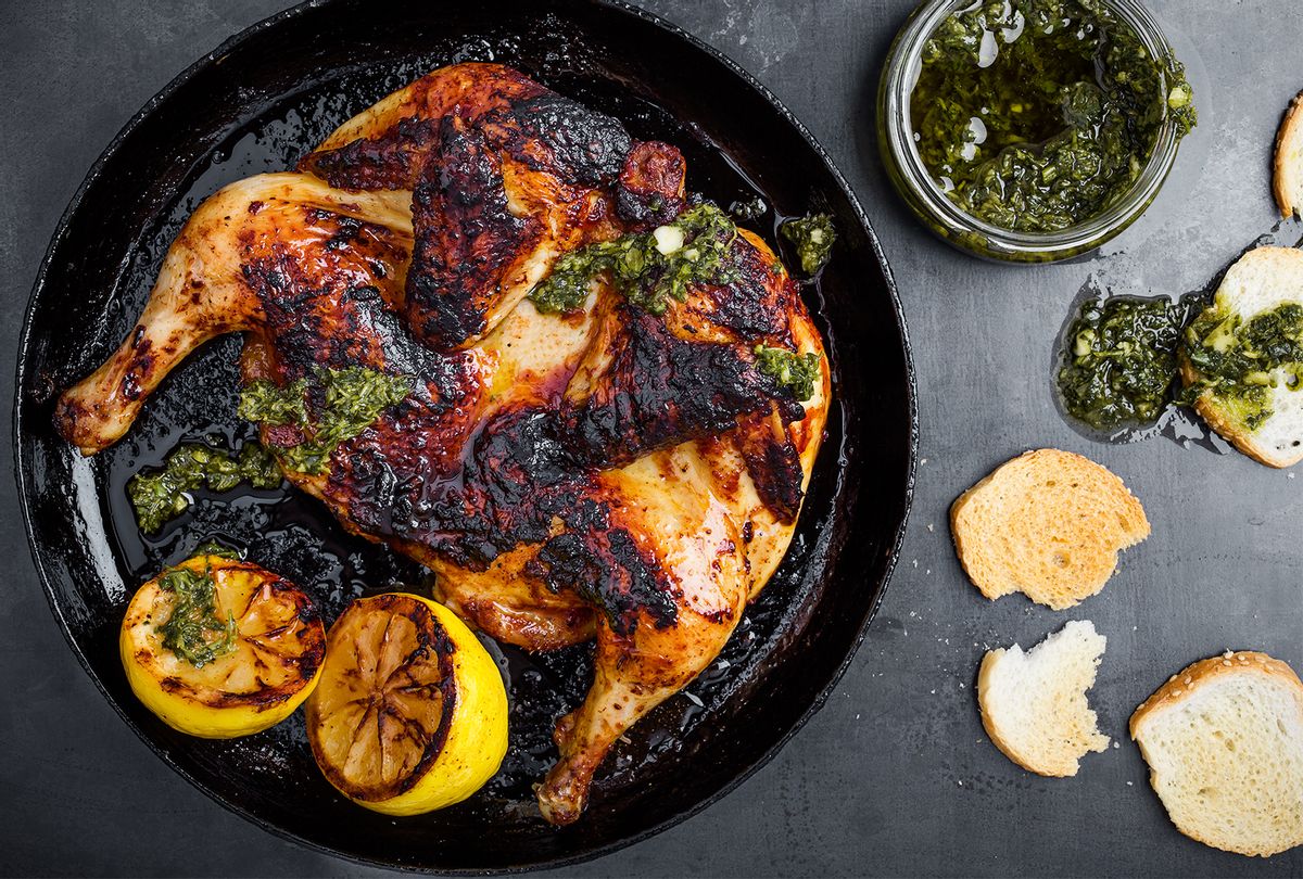 Barbequed chicken with chimichurri sauce in rustic cast iron pan o (Getty Images / istetiana)