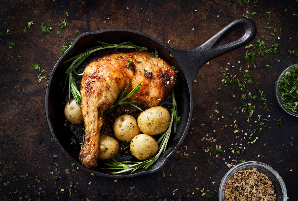 Roasted chicken leg and small potatoes with seasoning in cast iron skillet (Getty Images / EasyBuy4u)