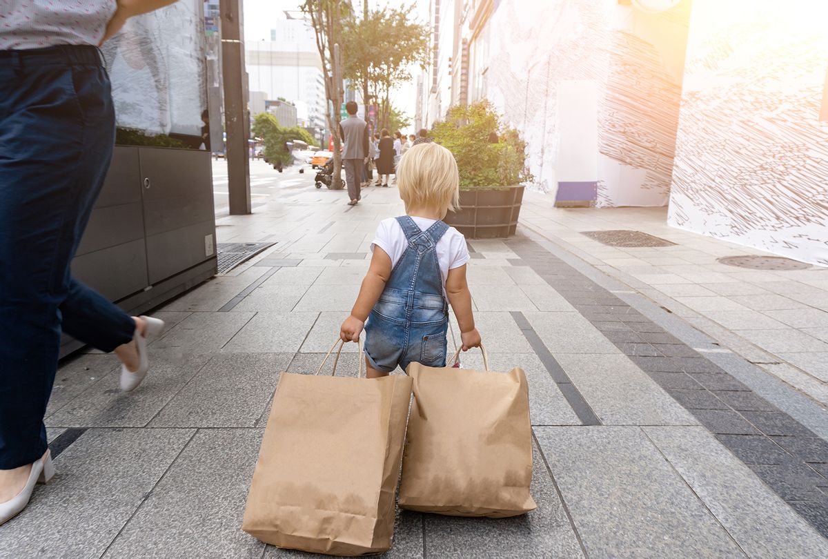 Small child carrying shopping bags (Getty Images / MariaMikhaylichenko)