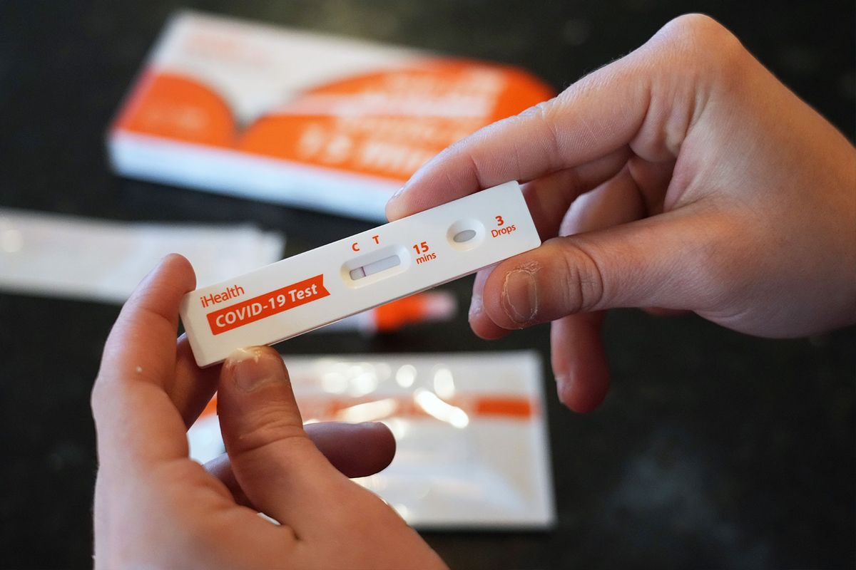 A Walmart worker shows she tested negative after using one of the new government-issued COVID-19 Antigen Rapid test kits she received to take a self-test while at home on February 8, 2022 in Provo, Utah. The test kits are arriving as COVID positive test results are starting to fall in many states. (George Frey/Getty Images)