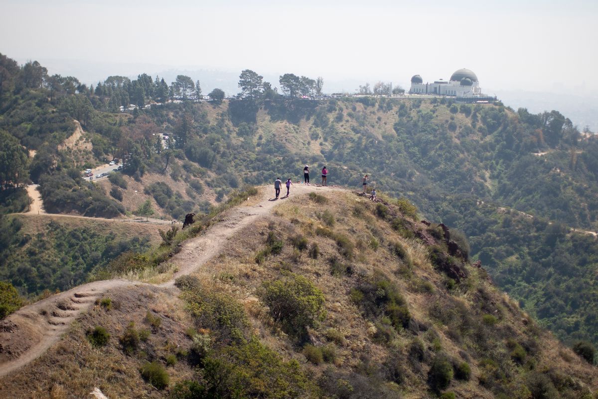 People hike along a ridge overlooking the Griffith Observatory (Photo by David McNew/Getty Images)