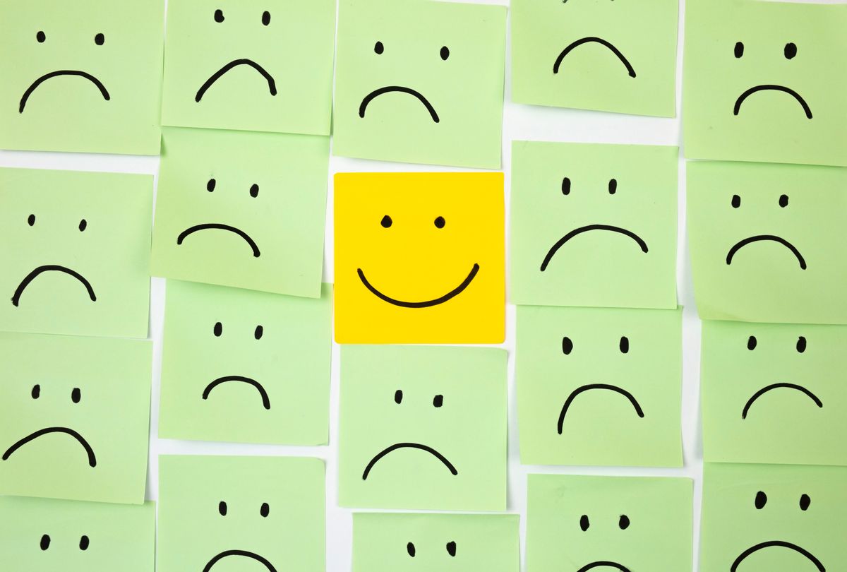 Sad faces on sticky notes with one happy one
 (Getty Images / mikroman6)