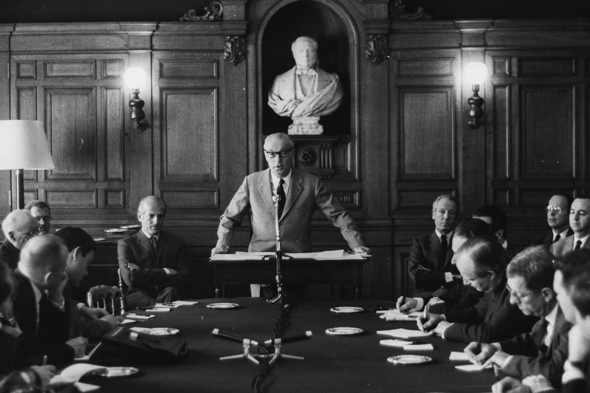 Baron Guy de Rothschild (standing) speaking during a press conference celebrating the 150th anniversary of the Rothschild Brothers Bank, watched by Baron Elie de Rothschild (left) and Baron Alain de Rothschild (right), April 26th 1967. (Keystone Features/Hulton Archive/Getty Images)