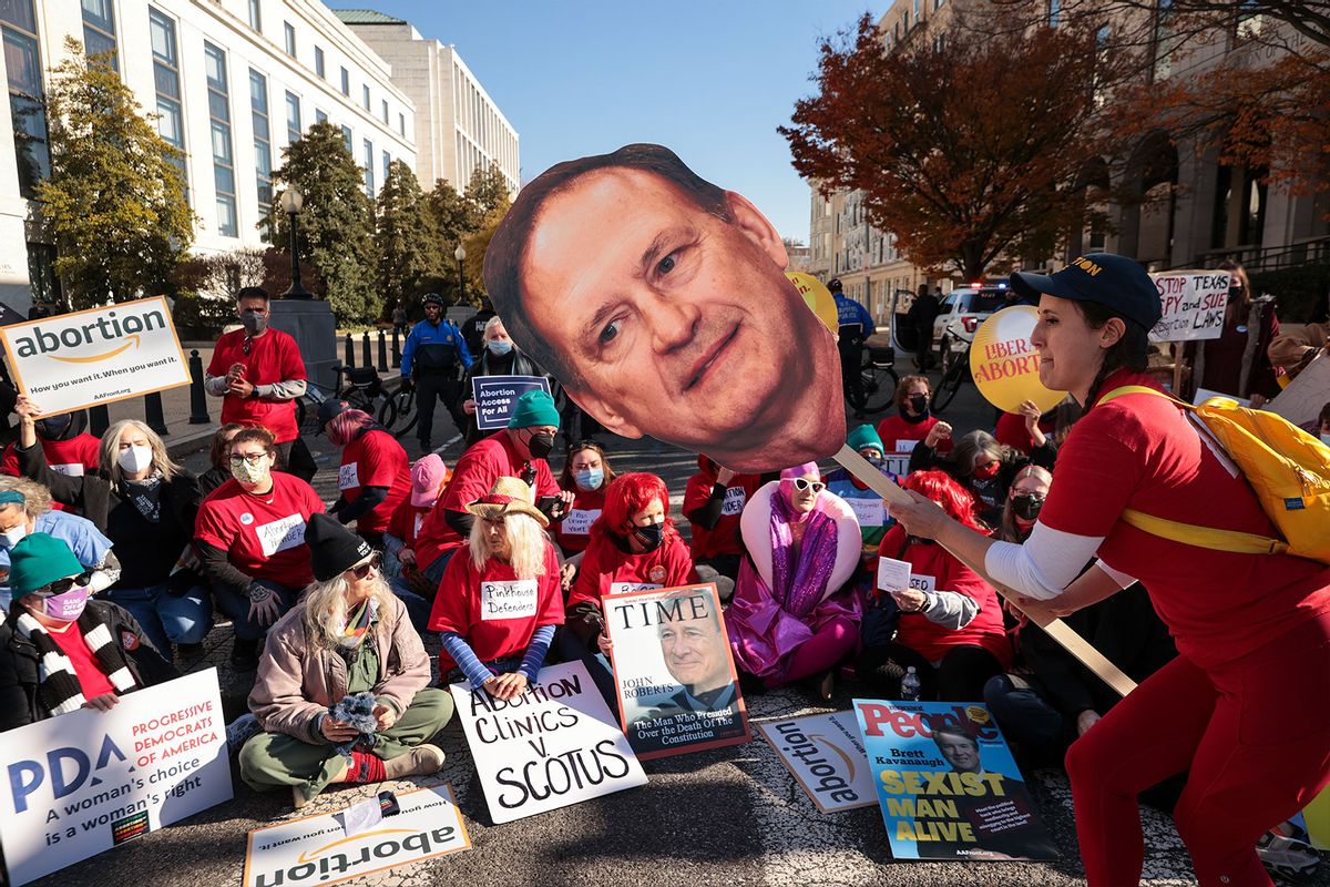 An activist with The Center for Popular Democracy Action holds a photo of U.S. Supreme Court Justice Samuel Alito as they block an intersection during a demonstration in front of the U.S. Supreme Court on December 01, 2021 in Washington, DC. (Chip Somodevilla/Getty Images)